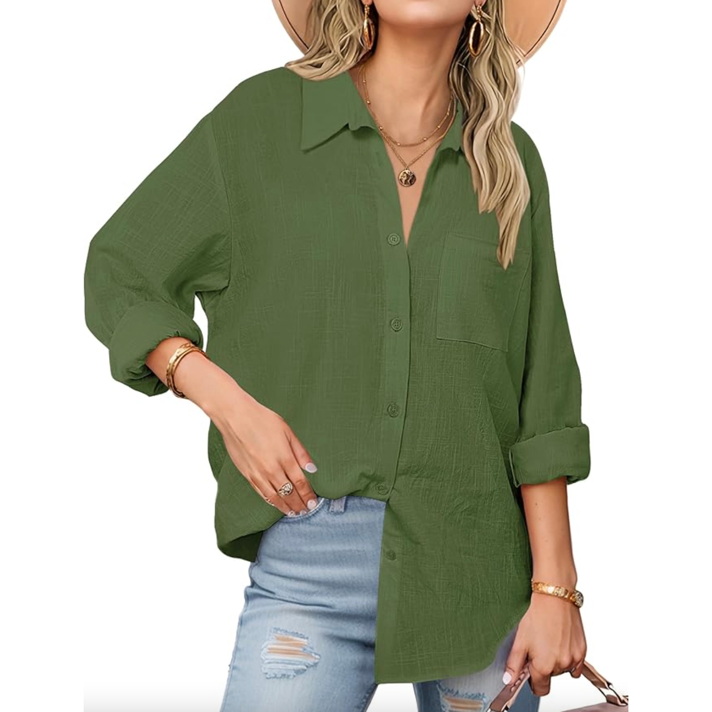 A person is wearing a green button-up shirt with rolled-up sleeves, paired with ripped jeans and accessorized with a wide-brimmed hat, necklaces, bracelets, and rings.