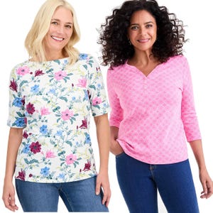 Two women are wearing casual tops; one is in a floral short-sleeve top with pink, blue, and burgundy flowers, and the other is in a pink quarter-sleeve henley with a light geometric pattern. Both are paired with blue jeans.