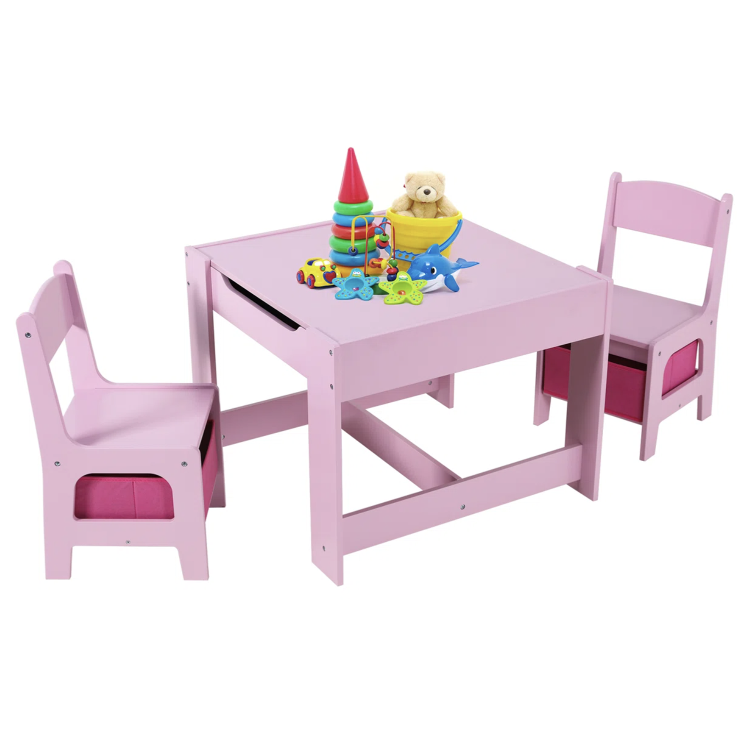 A pink children's table and chair set with storage baskets, featuring toys like a stacking ring, a teddy bear in a bowl, a toy car, and sea creature figures on the tabletop.