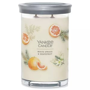 Yankee Candle White Spruce & Grapefruit features a two-wick design in a glass jar with a silver lid, decorated with images of grapefruit and spruce branches.