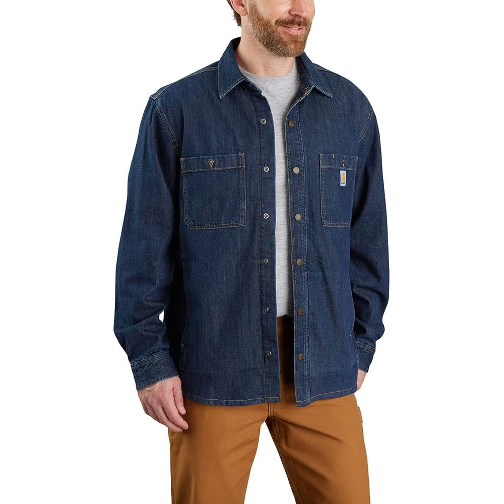 The Carhartt Fleece-Lined Shirt Jacket is a denim blue jacket with a button-up front and two chest pockets, featuring fleece lining for added warmth. It is paired with brown pants and a light gray shirt.