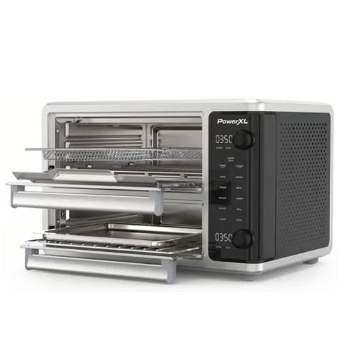 A silver PowerXL toaster oven with a digital display and multiple removable trays.