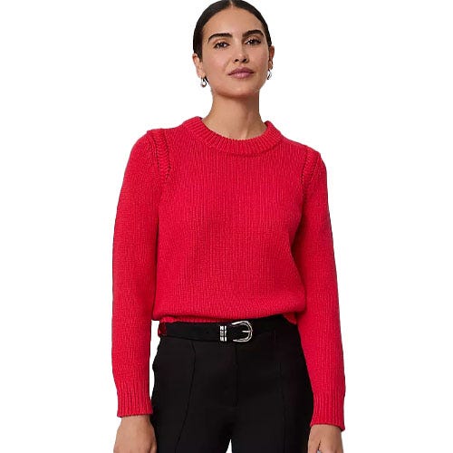 A woman is wearing a red long-sleeve sweater paired with black pants, accessorized with a black belt.