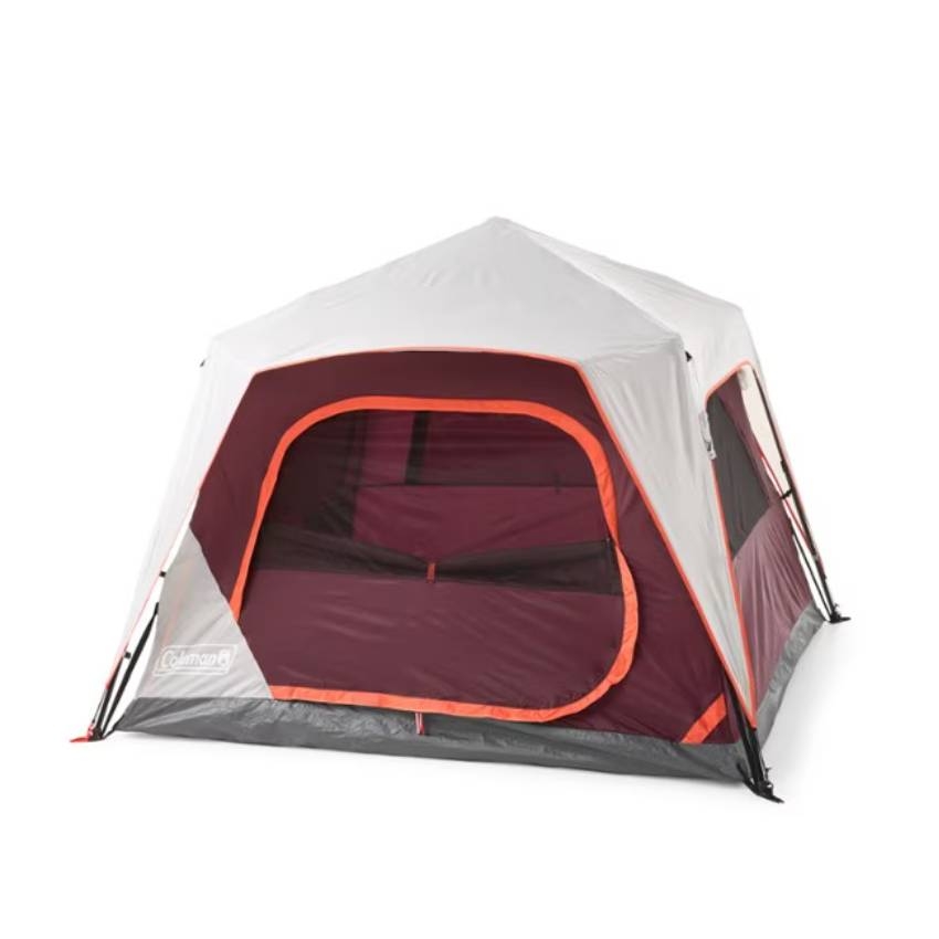 A Coleman cabin-style tent with a maroon and gray color scheme and orange trim, featuring a large front door and mesh windows.