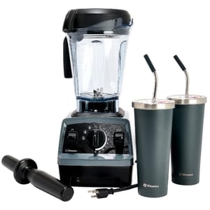 A Vitamix blender set includes a blender with a clear pitcher, two insulated cups with metal straws, and a tamper tool.