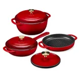Red enameled cast iron cookware set including a Dutch oven, skillet, and grill pan, each with gold-toned handles.