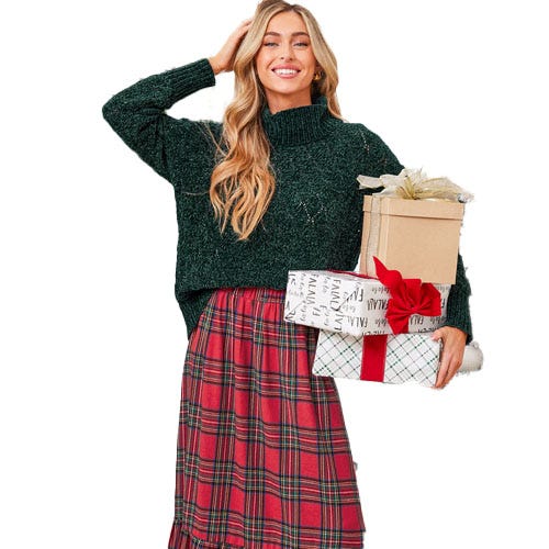A person in a green knitted sweater and red plaid skirt holds wrapped gifts, one with a red ribbon.