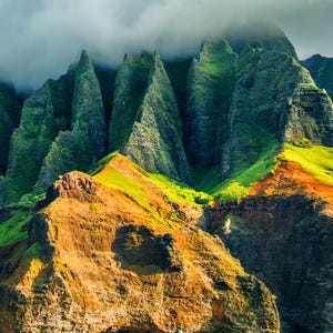 Lush green mountain peaks under a cloudy sky.