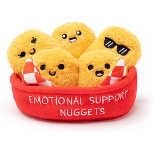 A set of plush yellow nuggets with cute facial expressions nestled in a red container labeled \“Emotional Support Nuggets,\“ featuring a checkered red and white fabric.