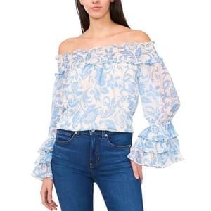 Off-the-shoulder blouse with a blue and white floral pattern, featuring ruffled details on the neckline and sleeves, paired with dark blue jeans.