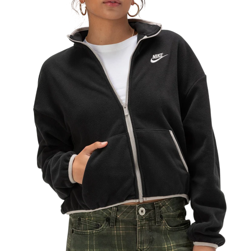 A person wears a black Nike zip-up fleece jacket, featuring the logo on the chest, paired with green plaid pants.