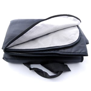 A foldable outdoor blanket with a water-resistant black exterior and a soft, light gray fleece interior, featuring a carry handle for easy transport.
