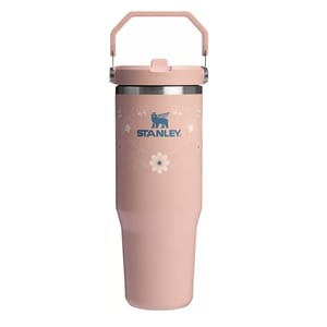 Stanley travel mug in pink with floral patterns, featuring a sturdy handle and the Stanley logo in blue.