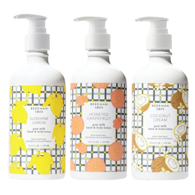 Three Beekman 1802 goat milk hand and body lotions: Sunshine Lemon, Honeyed Grapefruit, and Coconut Cream, each 12.5 fl oz (370 mL), featuring botanical oils and extracts in colorful patterned bottles.