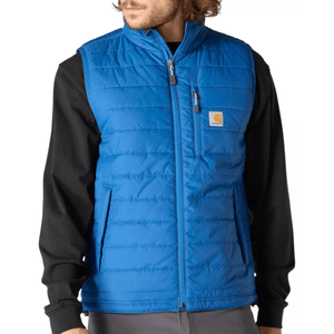 A man is wearing a blue quilted vest with front zip closure and pockets, paired with a black long-sleeve shirt underneath.