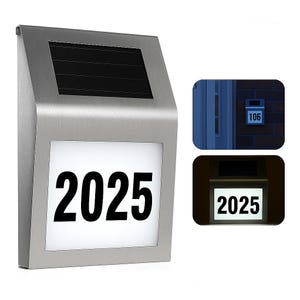 A solar-powered LED address sign with a stainless steel frame displays customizable numbers. It features a solar panel on top and lights up in low-light conditions to enhance visibility.
