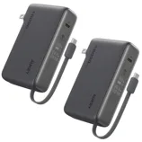 Two Aukey 10000mAh portable chargers with built-in retractable cables and digital displays showing battery levels.