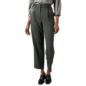 A person wearing high-waisted, dark green tailored pants with a pleated front, paired with a long-sleeved, cuffed shirt and black slip-on shoes.