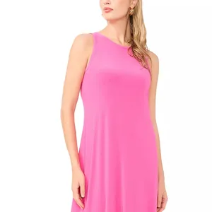 A sleeveless pink dress with a round neckline is being worn by a person with long, blonde hair and gold hoop earrings.