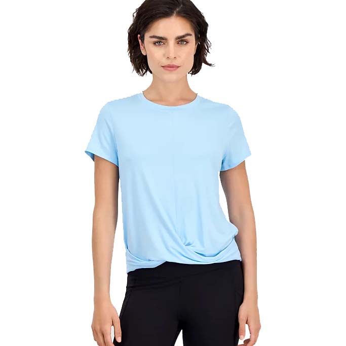 A woman is wearing a light blue short-sleeve T-shirt with a knot detail at the hem, paired with black pants.