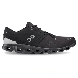 A black athletic shoe with distinctive cushioning and perforated sole design, featuring the On logo.