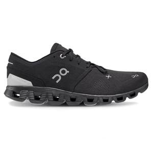 A black athletic shoe with distinctive cushioning and perforated sole design, featuring the On logo.