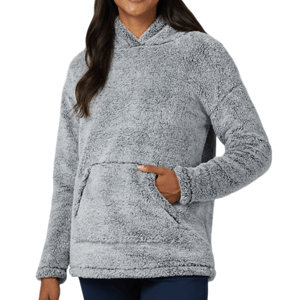 A woman is wearing a gray, plush, fleece hoodie with a large front pocket, featuring long sleeves and a cozy texture.