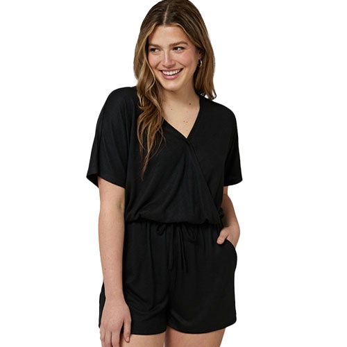 A woman is wearing a black romper with a V-neck, short sleeves, and a drawstring waist.