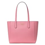 A pink leather tote bag with long handles, featuring a discreet logo on the front.
