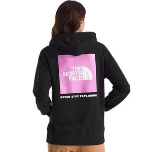 A person is wearing a black hoodie with a pink square featuring \“THE NORTH FACE\“ logo and the phrase \“NEVER STOP EXPLORING\“ printed on the back.