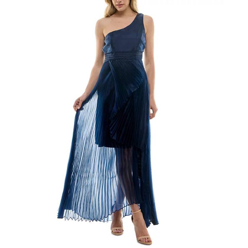 A navy blue, one-shoulder gown with a pleated organza overlay and asymmetrical hem, featuring a fitted bodice and sheer maxi length skirt.