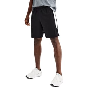 A person is wearing black athletic shorts with a white stripe, a gray shirt, and white sneakers.