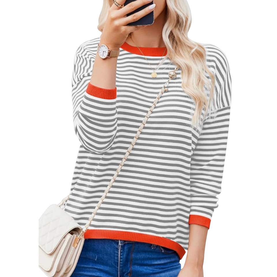 Woman in a striped long-sleeve shirt with red trim, wearing jeans, a quilted white handbag with a chain strap, a wristwatch, and layered necklaces.