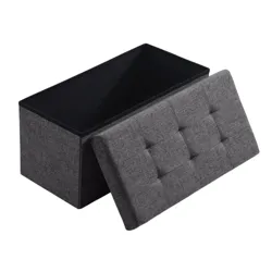 A gray fabric storage ottoman with a tufted lid, partially open to reveal internal storage space.