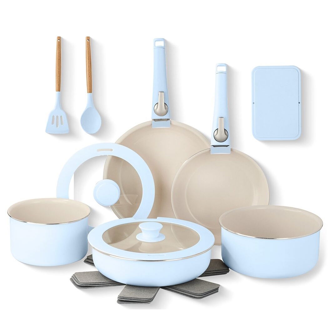 A light blue cookware set with two frying pans, two pots (one with a lid), a spatula, a spoon, and a lid holder. Includes felt pan protectors and a rectangular organizer.