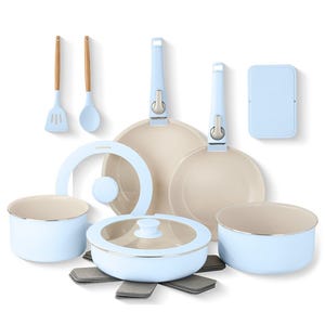 A light blue cookware set with two frying pans, two pots (one with a lid), a spatula, a spoon, and a lid holder. Includes felt pan protectors and a rectangular organizer.