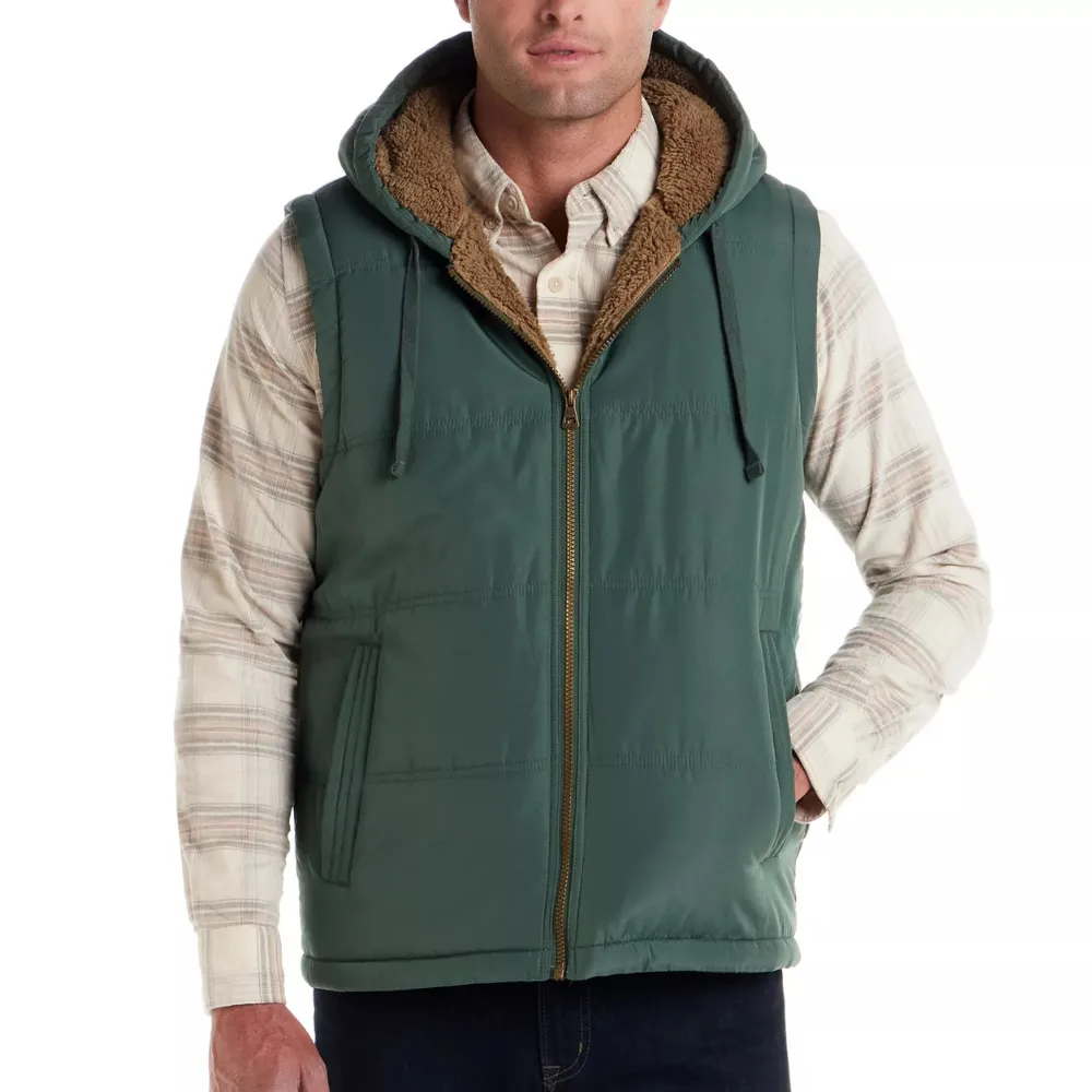 A man wears a green hooded vest with a fur lining, zipped over a plaid shirt.