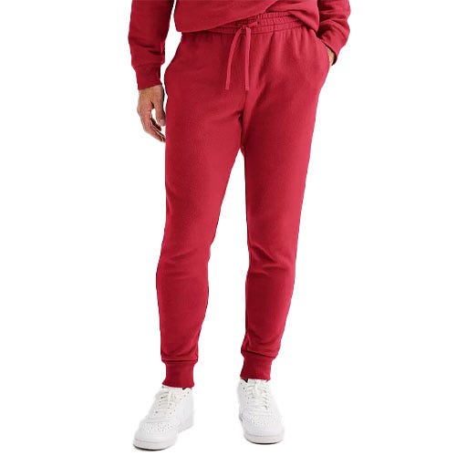 Red jogger sweatpants with an elastic waistband and drawstring, paired with white sneakers.