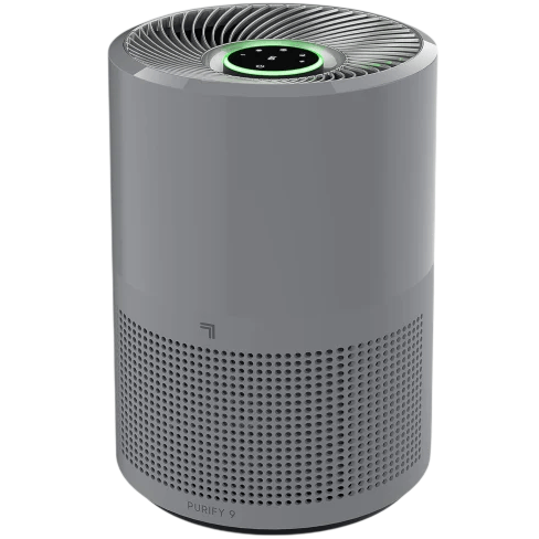 A cylindrical air purifier with a gray body, featuring a perforated lower section for air intake and a control panel on top with a glowing green ring.