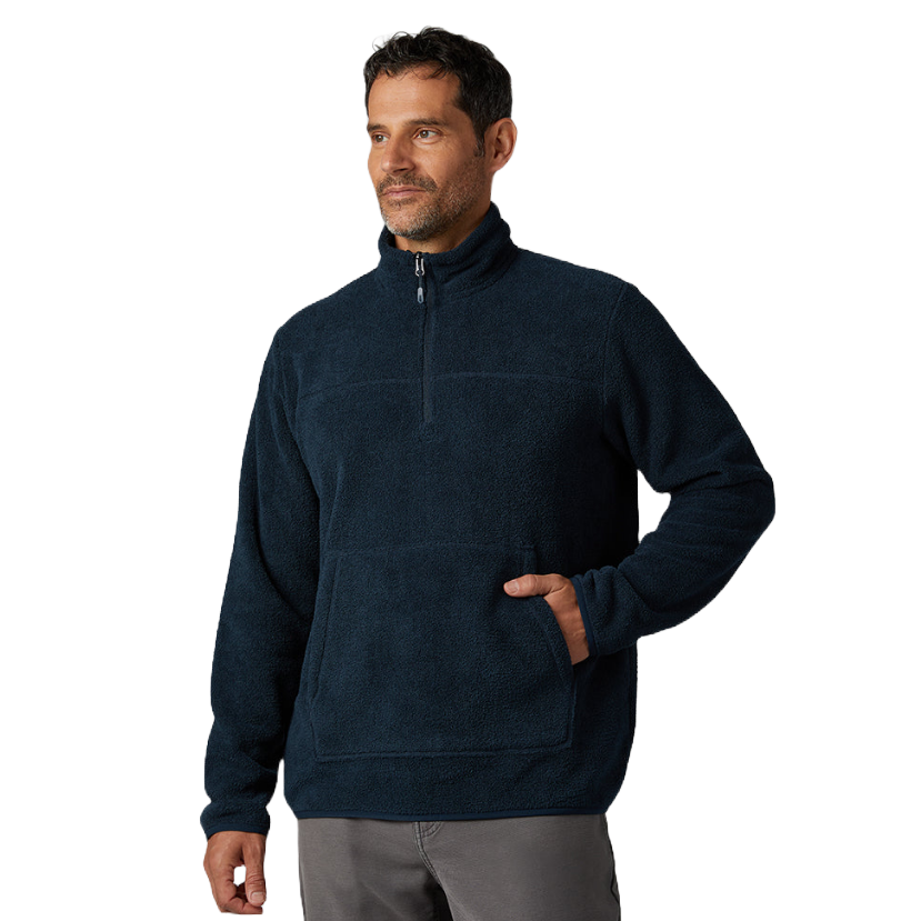 A man is wearing a dark blue fleece pullover with a quarter zip and a large front pocket, paired with gray pants.