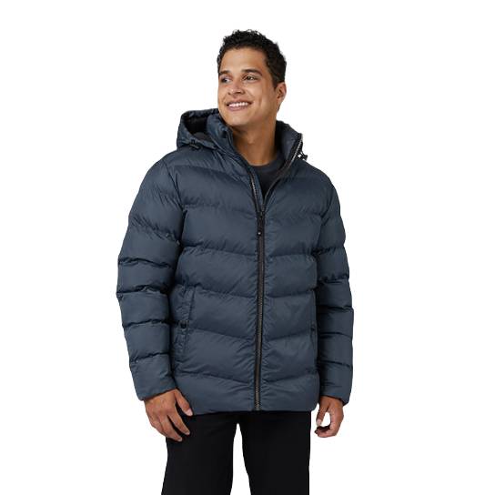 A man models a navy blue 32 Degrees Puffer Jacket with a hood, featuring quilted design and zip closure, suitable for cold weather.