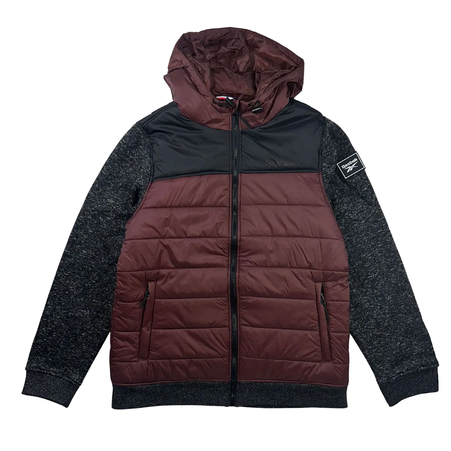 A maroon and black Reebok puffer jacket with a hood and zippered pockets, featuring dark gray sleeves with a Reebok logo patch on the left sleeve.