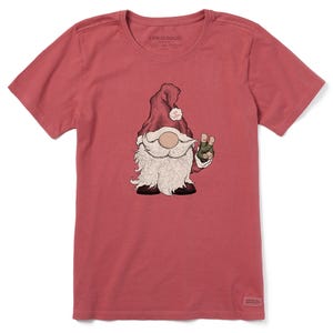 A red T-shirt features a graphic of a gnome dressed as Santa with a white beard, wearing a red hat, and holding up a peace sign with one hand. The shirt has \“Life is Good\“ printed inside the collar.