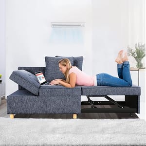 A woman is relaxing on a blue sectional sofa with an adjustable headrest and a built-in storage compartment.