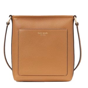 A tan Kate Spade New York crossbody bag with a front pocket and a long adjustable strap.