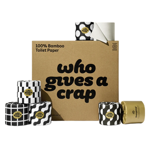 Box and rolls of \“Who Gives a Crap\“ 100% bamboo toilet paper, featuring black and white geometric designs, plus a gold roll labeled \“Emergency.\“