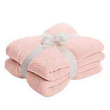 A pink towel set tied with a white ribbon.