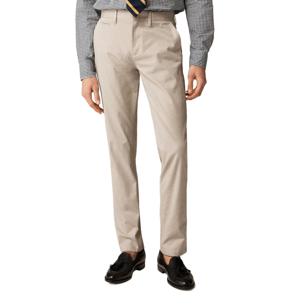 A man is wearing beige dress pants paired with a black and white checkered shirt, a striped tie, and black loafers.