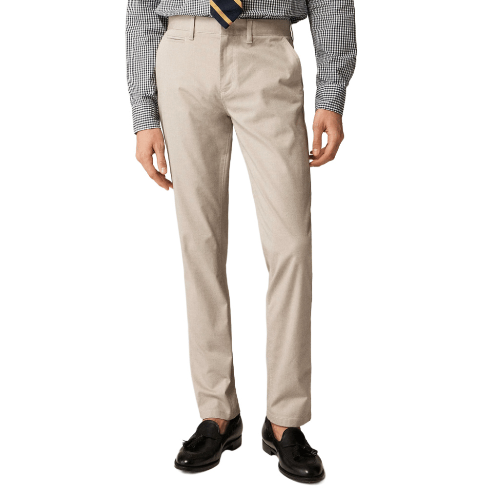 A man is wearing beige dress pants paired with a black and white checkered shirt, a striped tie, and black loafers.