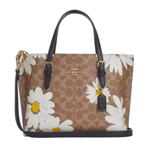 Coach Mollie 25 tote features a brown monogram print with large white daisy patterns, leather detailing, and gold-tone hardware.